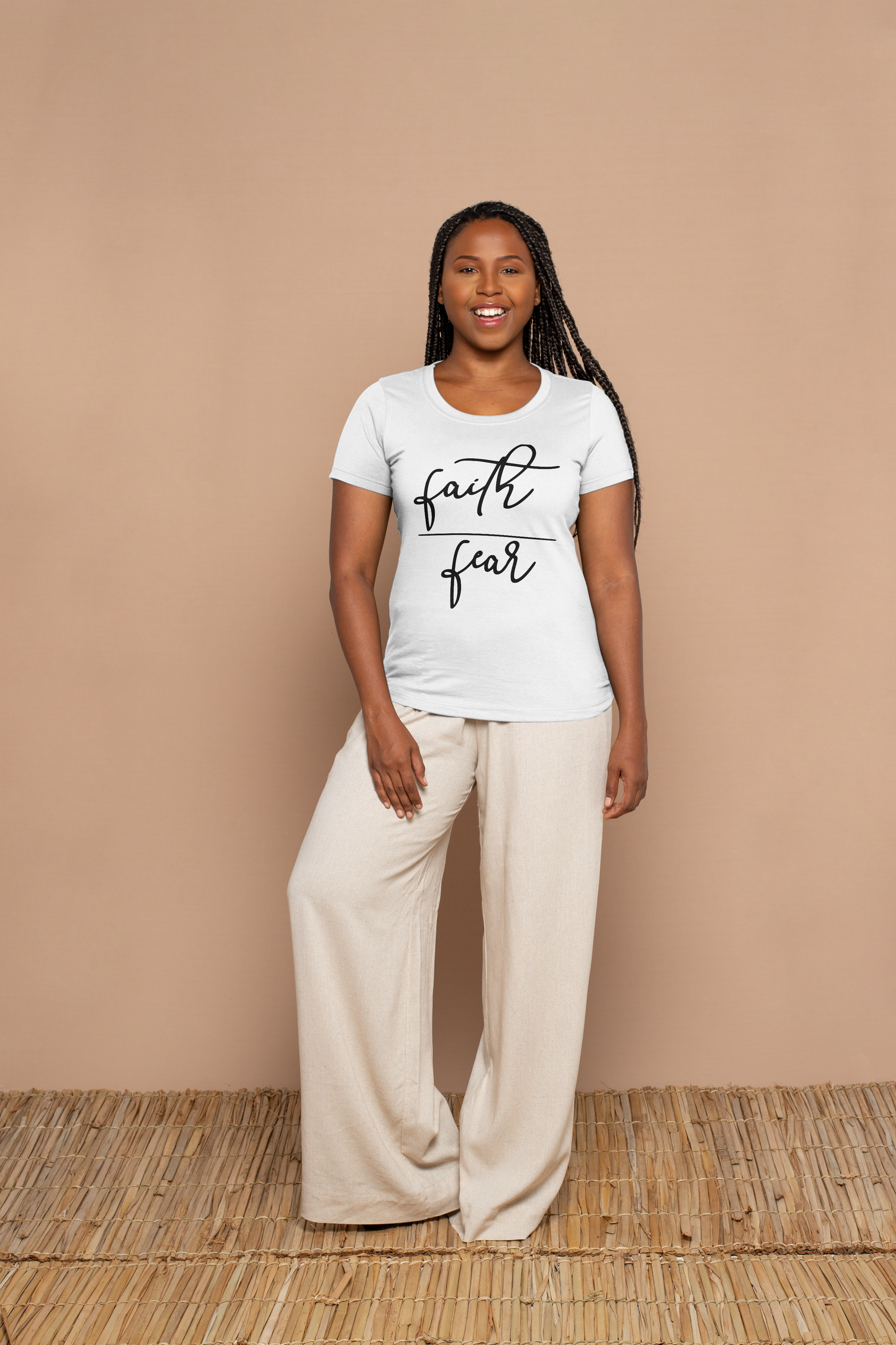 Woman wearing a white t-shirt with 'faith over fear' text on a beige background