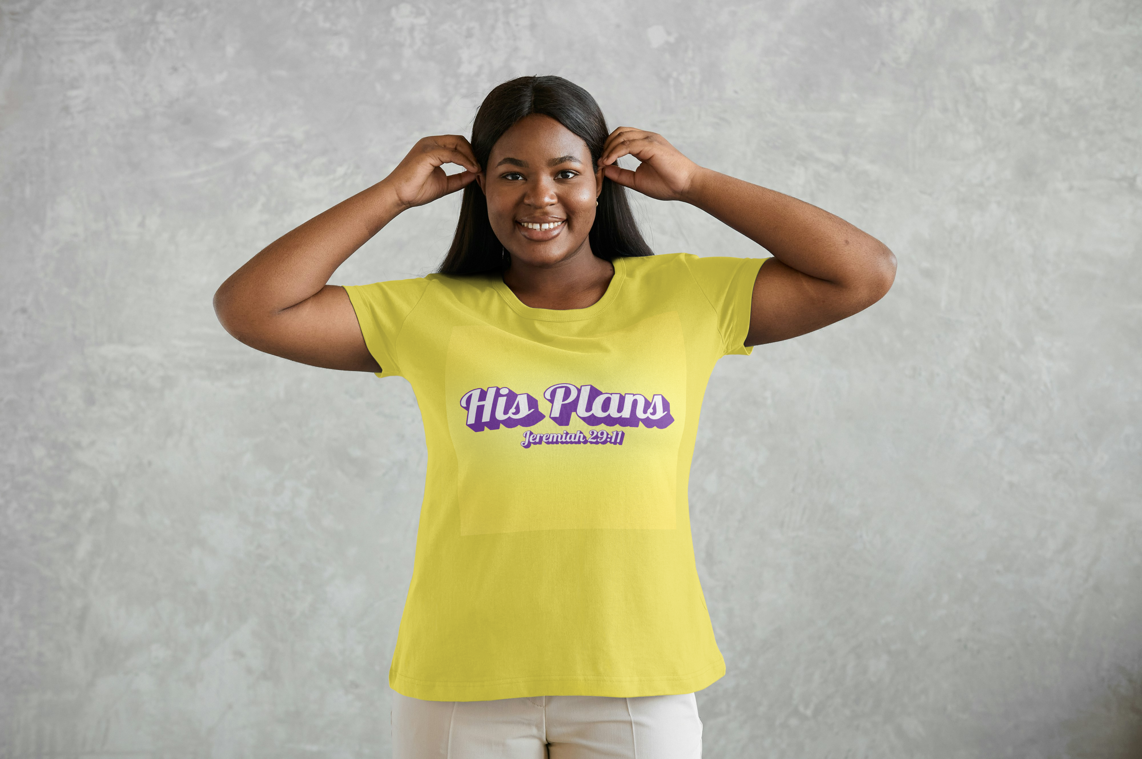 Person wearing a yellow t-shirt with text His Plans on a gray background